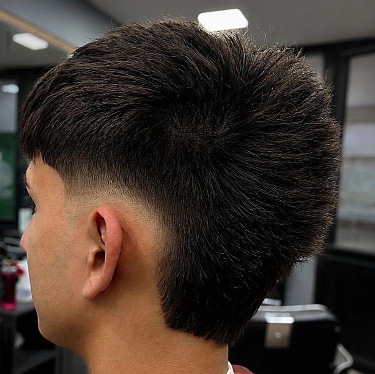 Mullet moderno con textura arriba, desvanecido bajo en el costado y más largo en la nuca